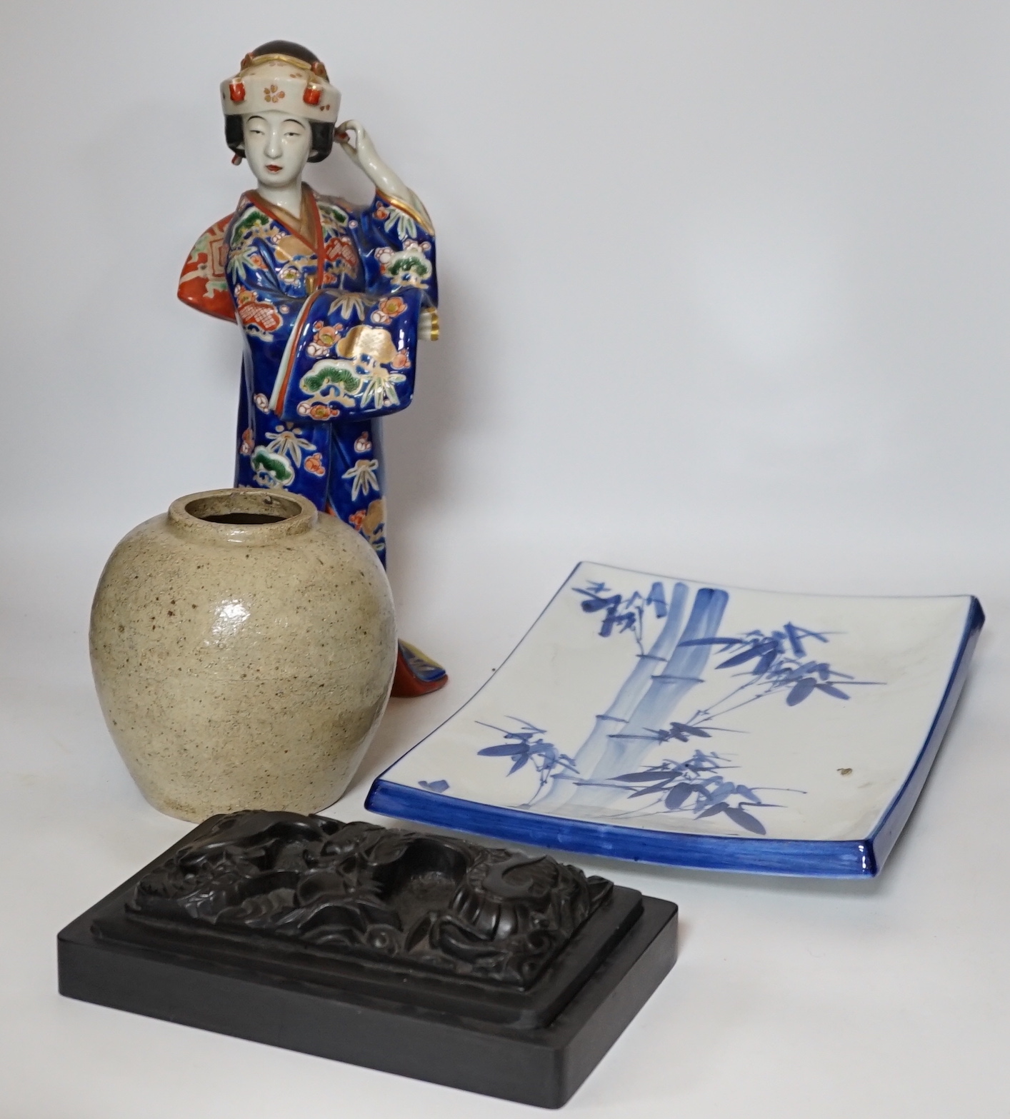 A 20th century Chinese porcelain figure, a stoneware jar, a ‘dragon’ inkstone and a Japanese dish, figure 37cm